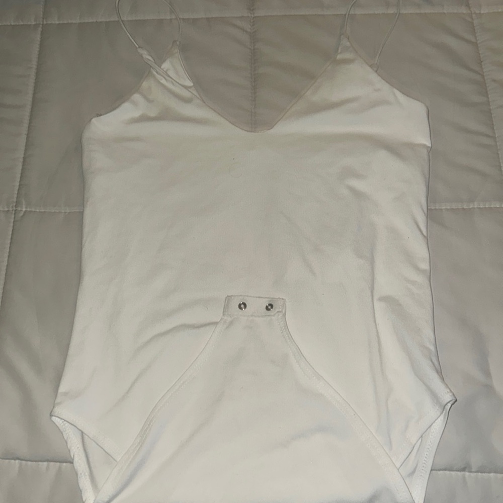 White strapped body suit, buttons on the bottom